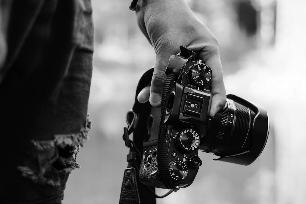 Street photographer carries his DSLR camera