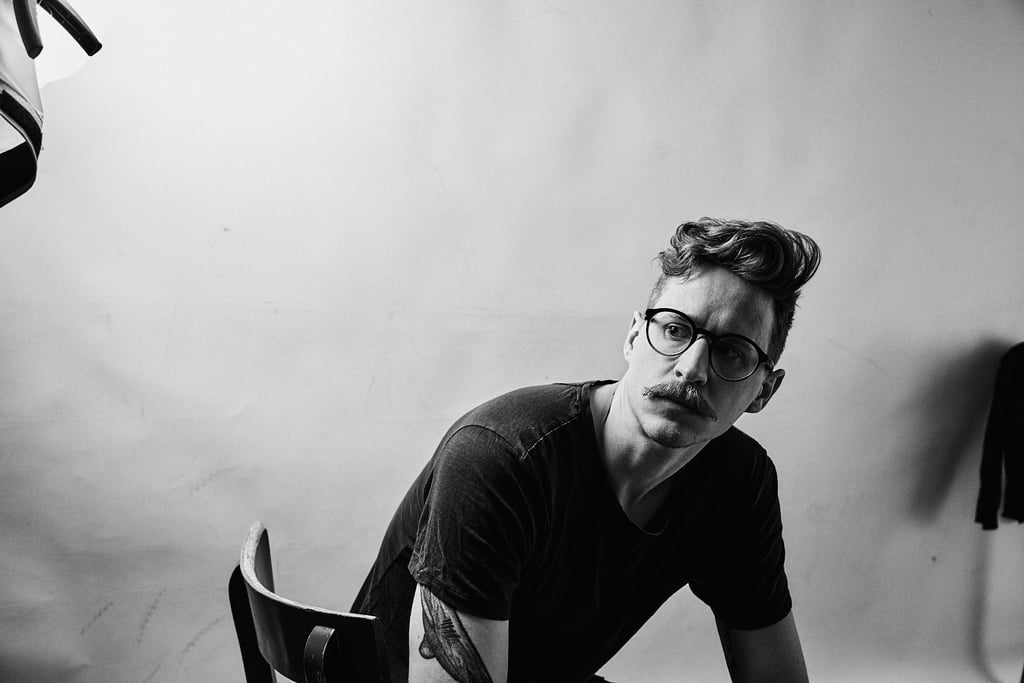 A man sitting on a chair in a photography studio.