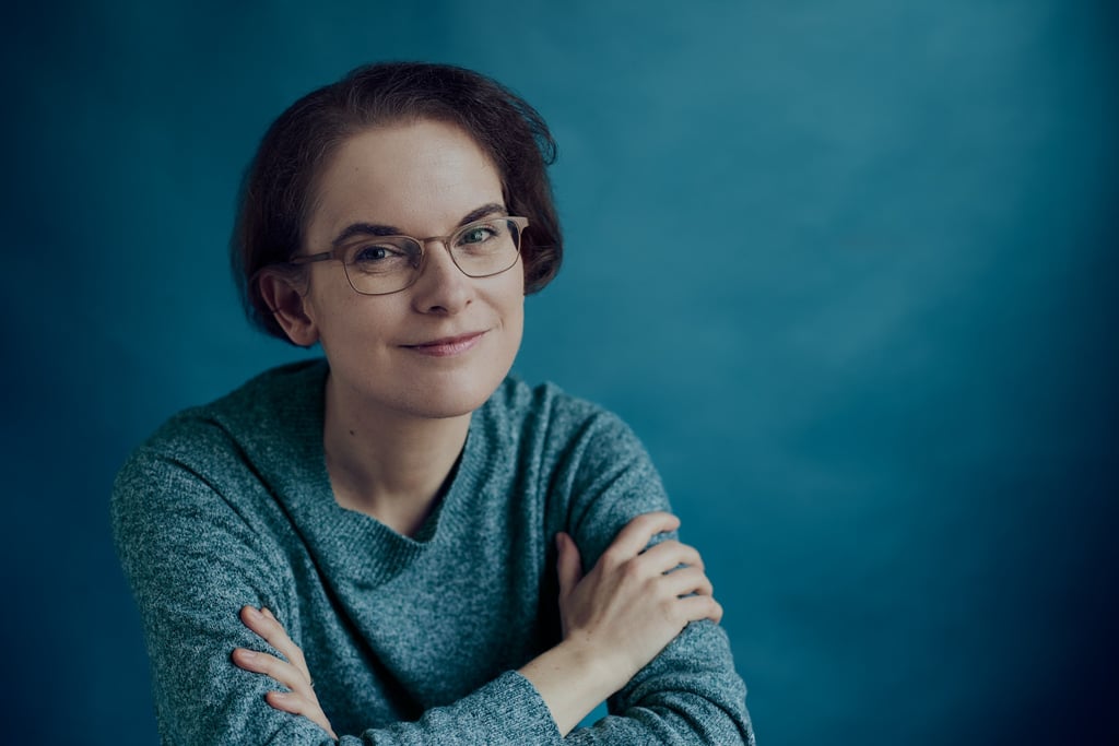 Kathrin Tordasi sitting in a studio with crossed arms.
