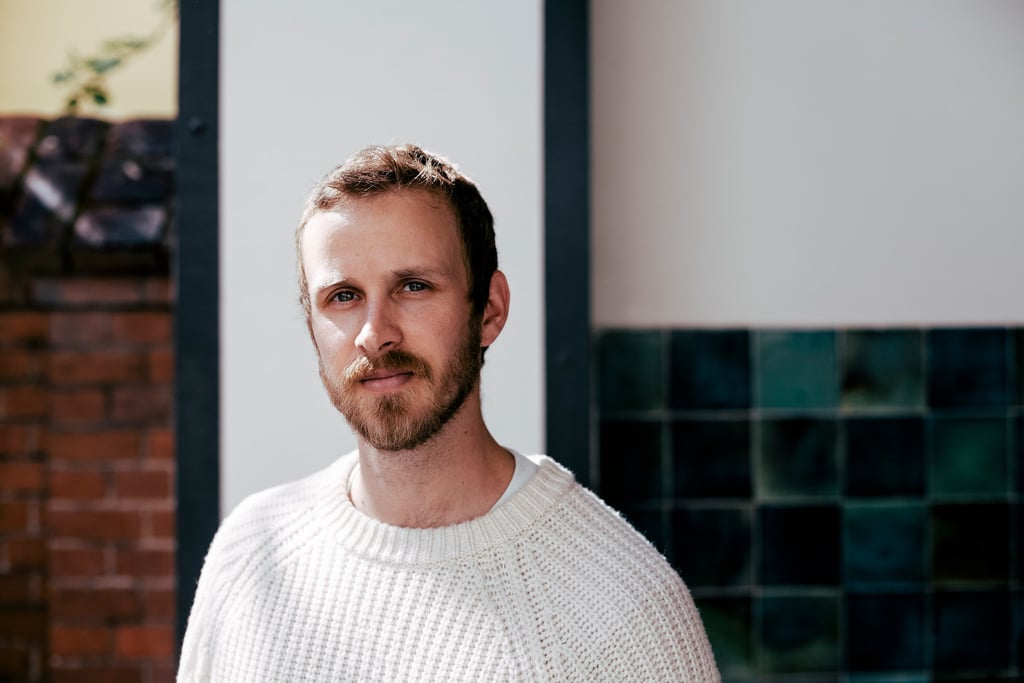 A portrait of a young man in a white sweater.