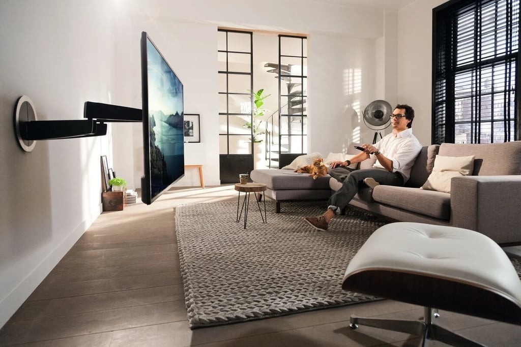 A couple enjoying a movie in a luxury London living room featuring a custom motorised TV mount 