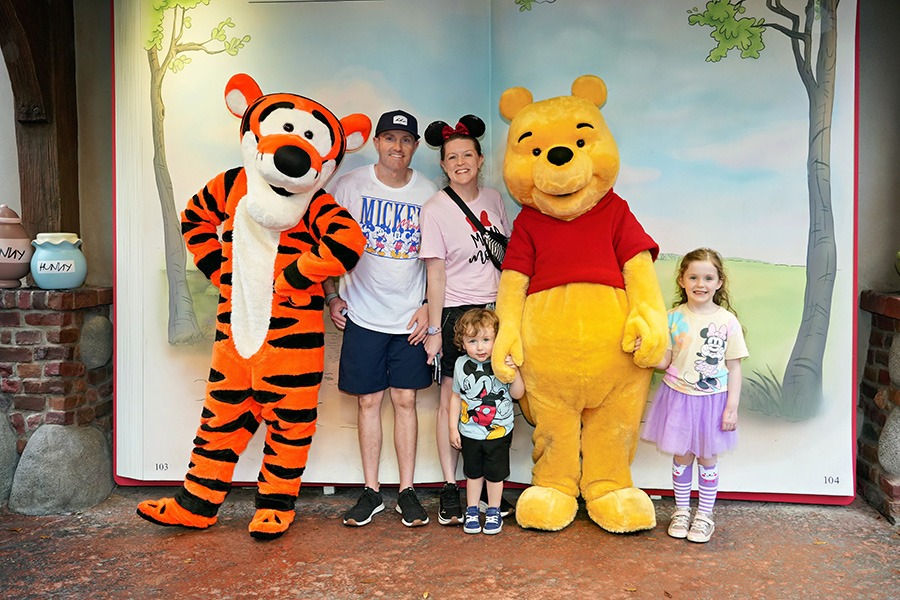 Aimee Cochrane and family pictured with Winnie the Pooh and Tigger at Disney's Magic Kingdom® inside Walt Disney World®.
