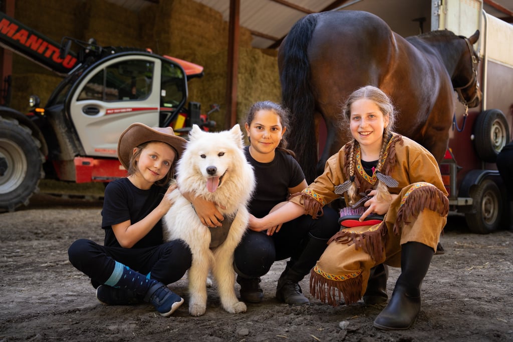 a boy in a cowboy hat and a dog are posing for a picture