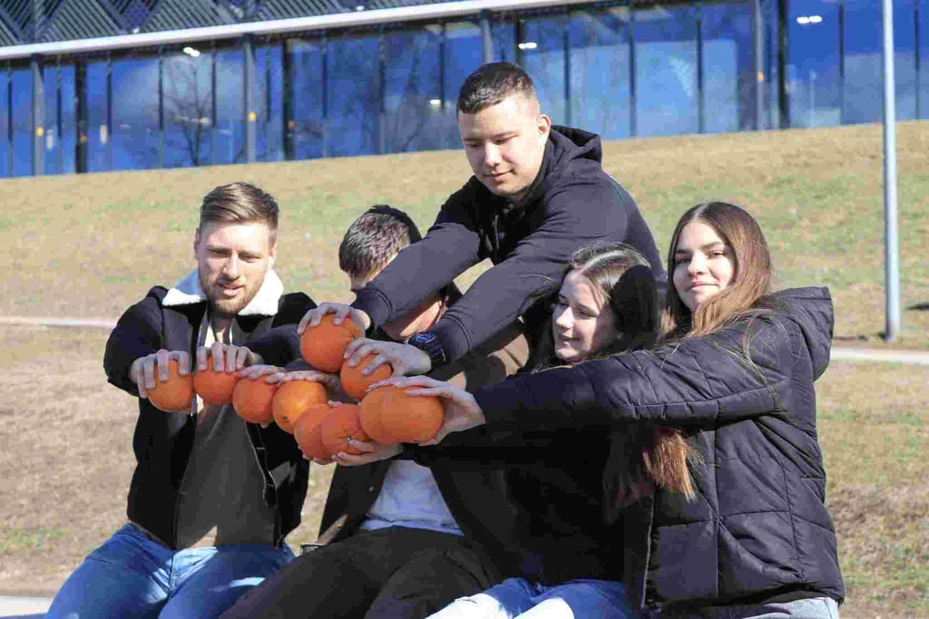 zmones lauke su apelsinais