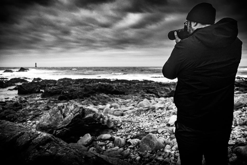 Photo noir et blanc de Anthony Leclerc qui prend une photo du phare de la jument