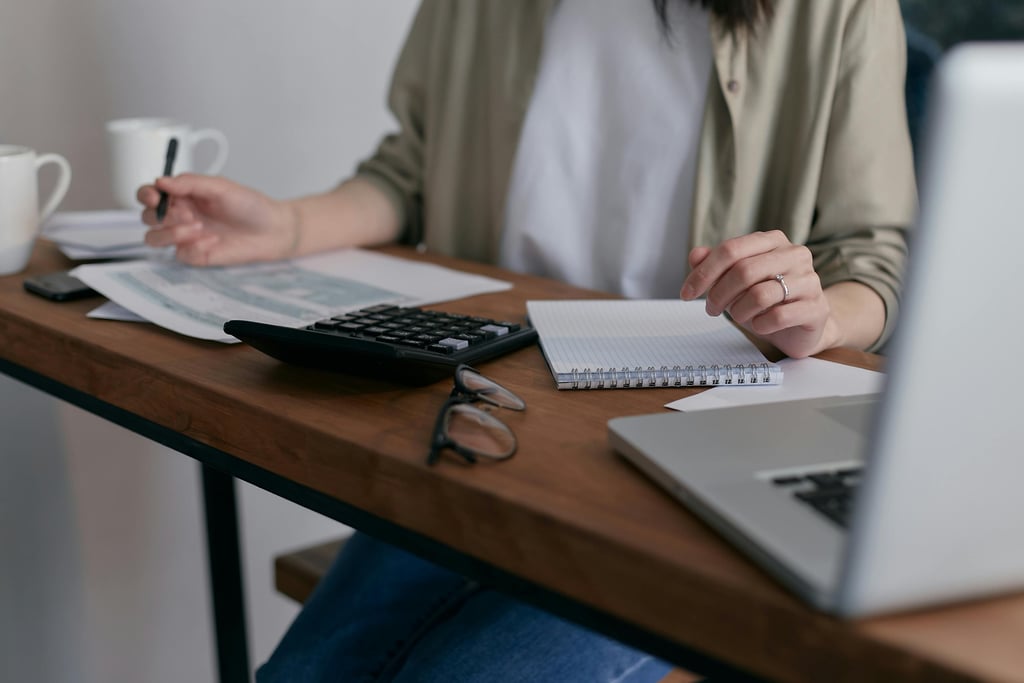 Assistante administrative : calculatrice et nombreux papiers triés et rangés, gestion des commandes