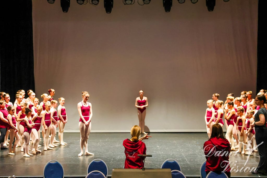 a group of young girls in red and white outfits on stage