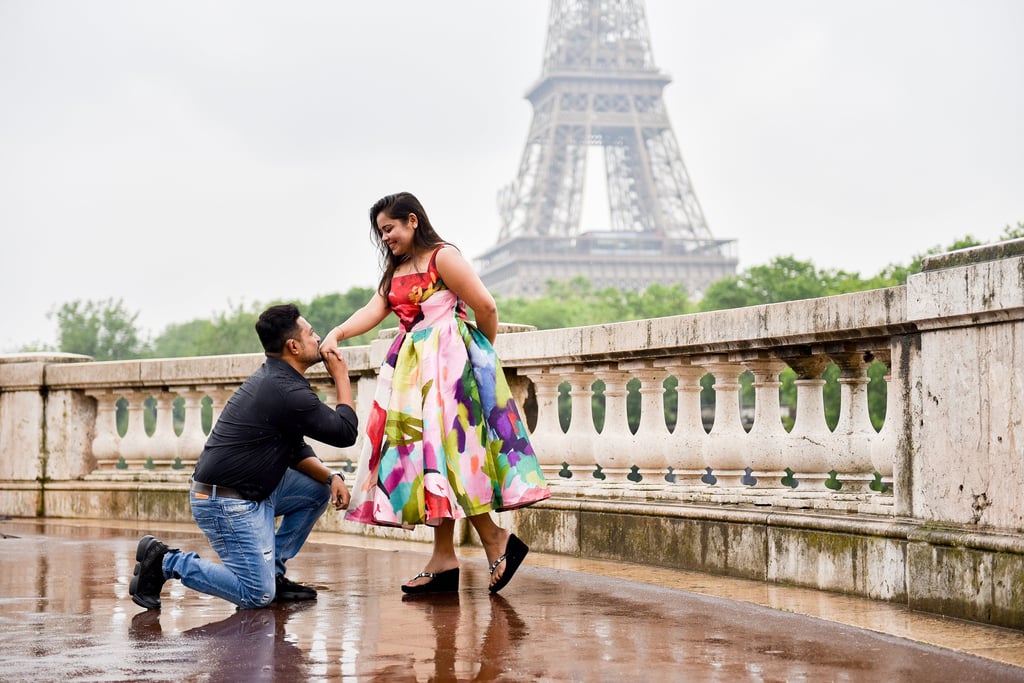 Un couple d'indien habillé sur leur 31 se font la cour sur le pont Bir Hakeim un jour de pluie, avec la tour eiffel en fond