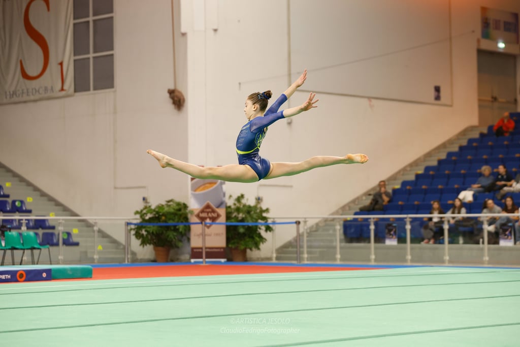 Gymnast performing a high split leap jump at PAla Turismo Jesolo