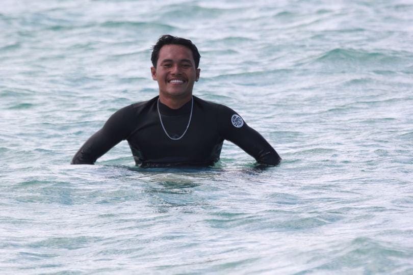 Romi smiling warmly at Paradise Surf School Lombok, embodying the friendly spirit of surfing and instruction.
