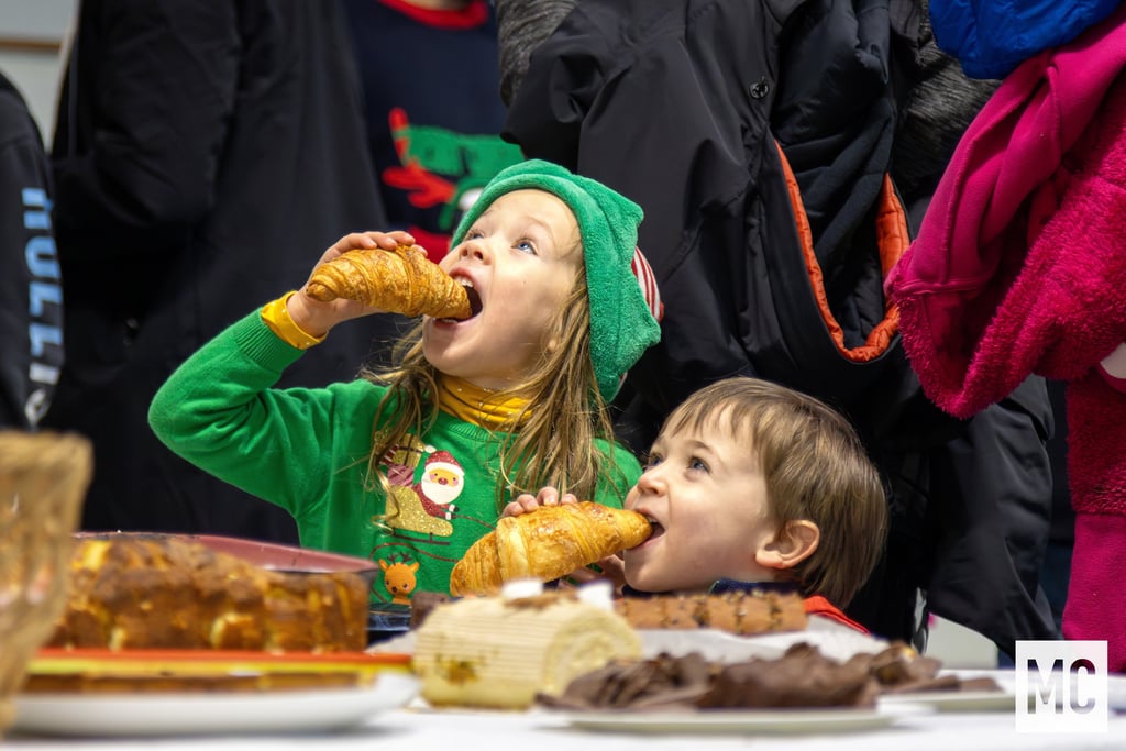 a boy and girl eating pastries at a table
