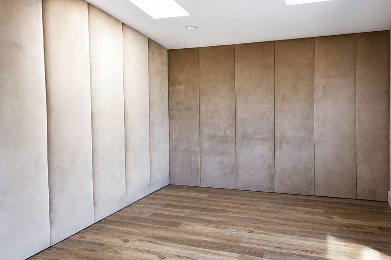 Elegant suede wall panels in neutral tones with wood flooring, custom-designed for a private theater room by Solo Home Decor.
