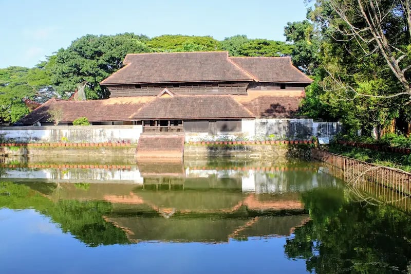 Rear view of Krishnapuram Palace in Kerala with a serene pond in the foreground.