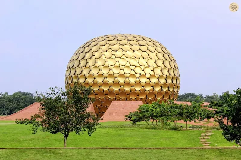 View of Matrimandir surrounded by green lawns in Auroville.