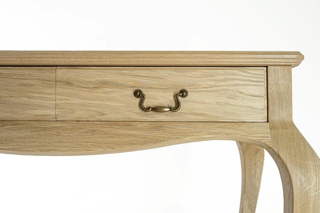 Close-up of an oak console table drawer with an antique-style metal handle