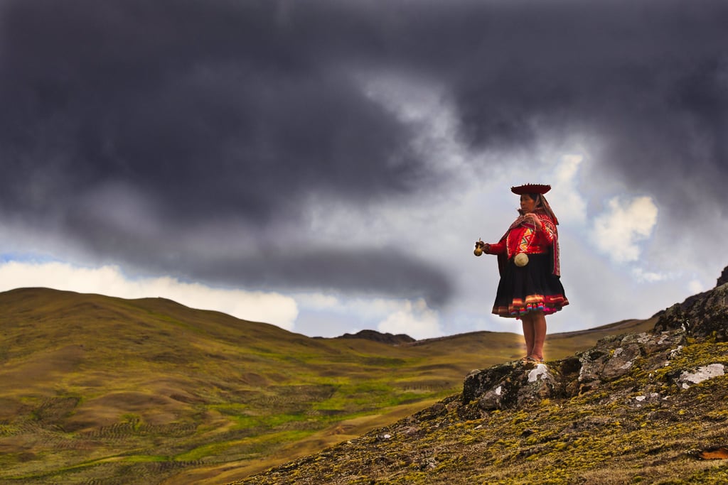 Photographer capturing Quechua weaver at traditional loom in Lares Valley, Peru