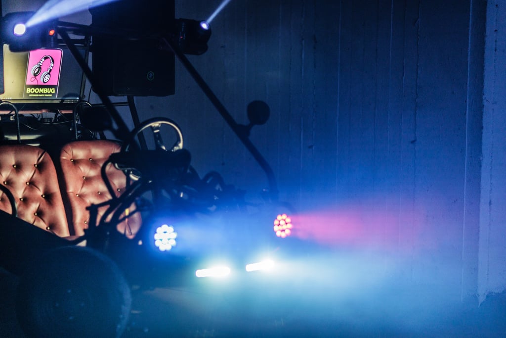 Custom Boombug party camper with stage lights and DJ equipment in a dark, atmospheric venue.