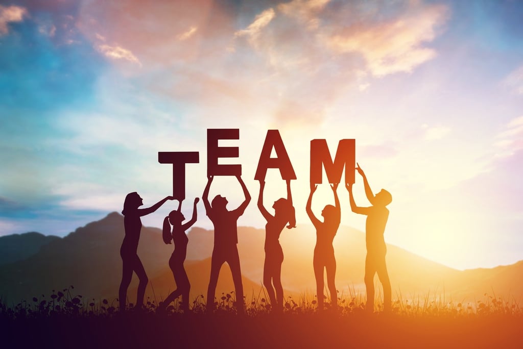 a group of people holding up a team building sign