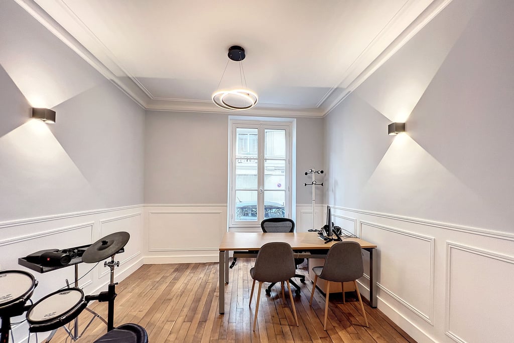 a room with a table and chairs and a drum set up