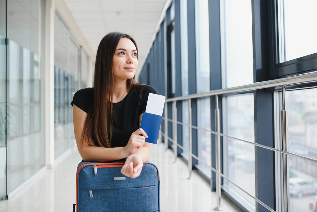 a woman holding a passport, airline ticket and dominican eticket