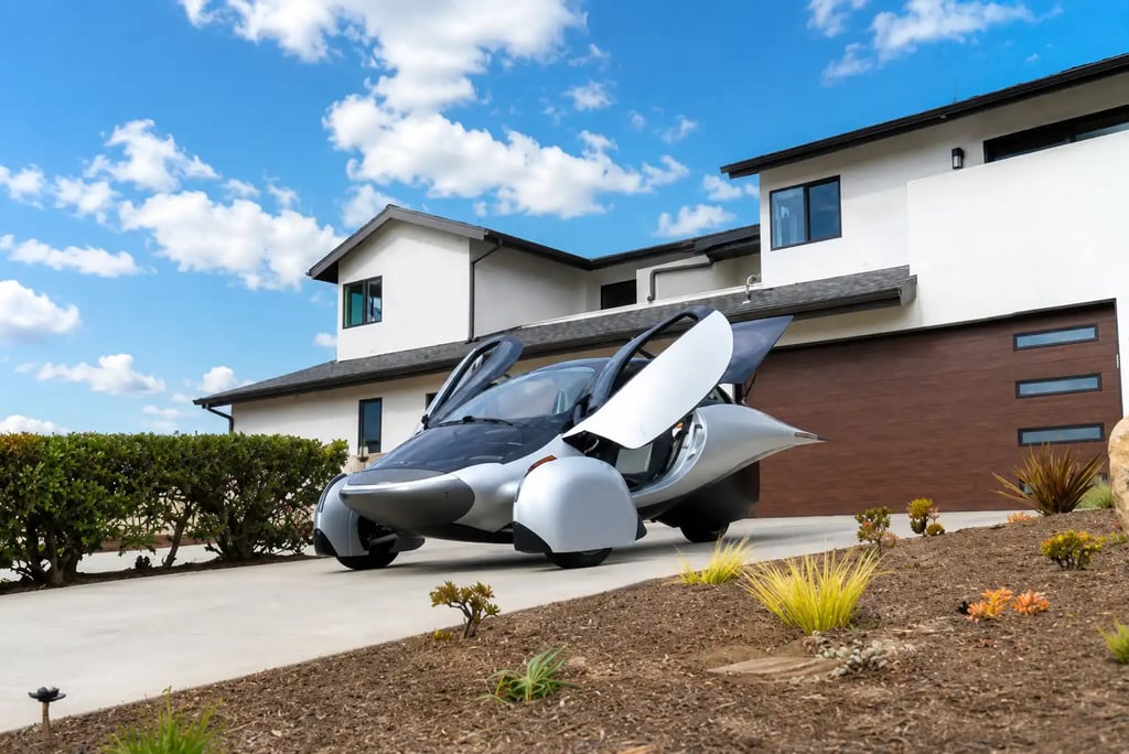 Aptera Solar EV estacionado em garagem residencial com portas abertas durante o dia
