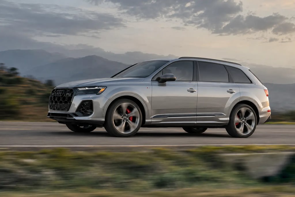 Audi Q7 2027 em movimento numa estrada com montanhas ao fundo