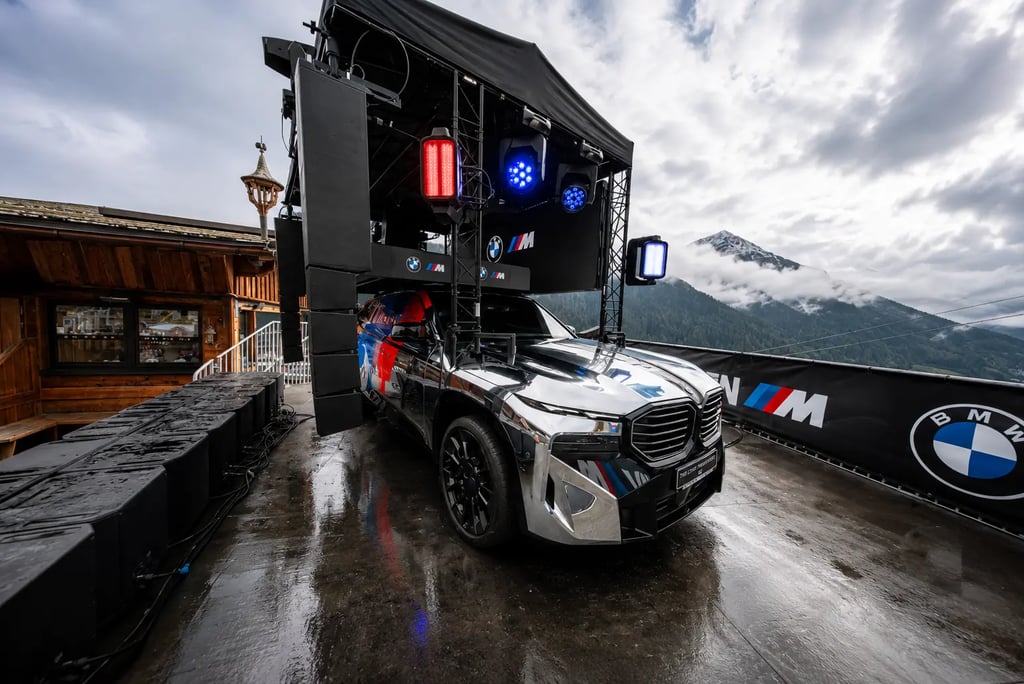 BMW XM Soundmachine exibido em festival automotivo com palco de DJ