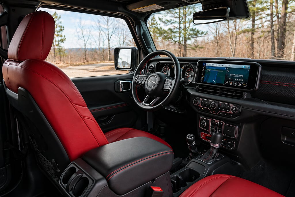 Interior do Jeep Rubicon com bancos vermelhos e painel moderno com multimídia