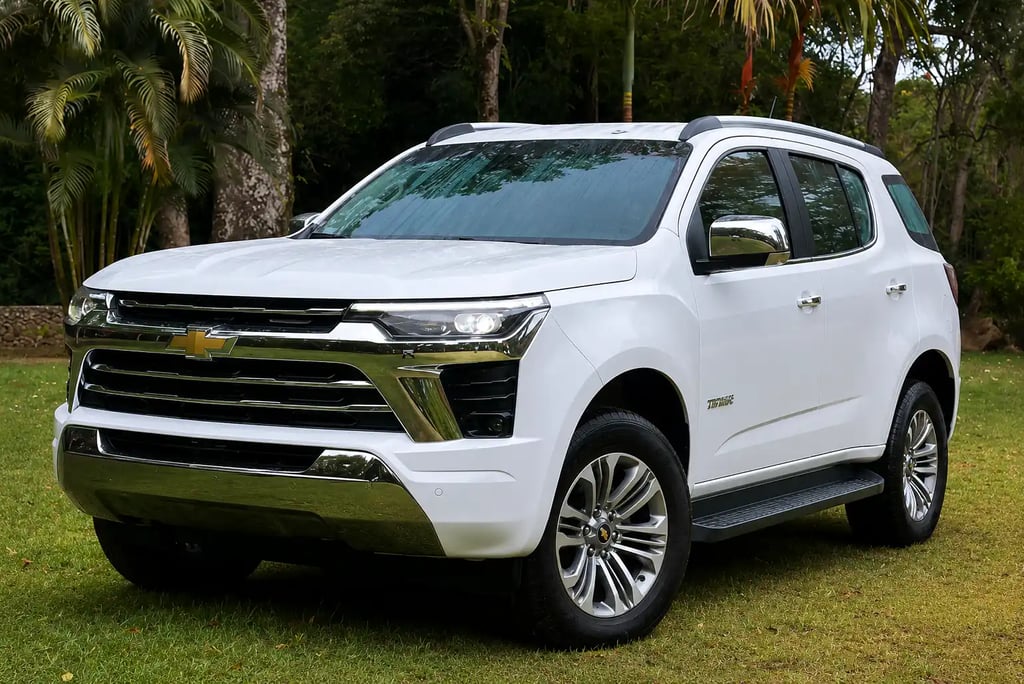 Chevrolet Trailblazer branca estacionada sobre gramado com fundo tropical