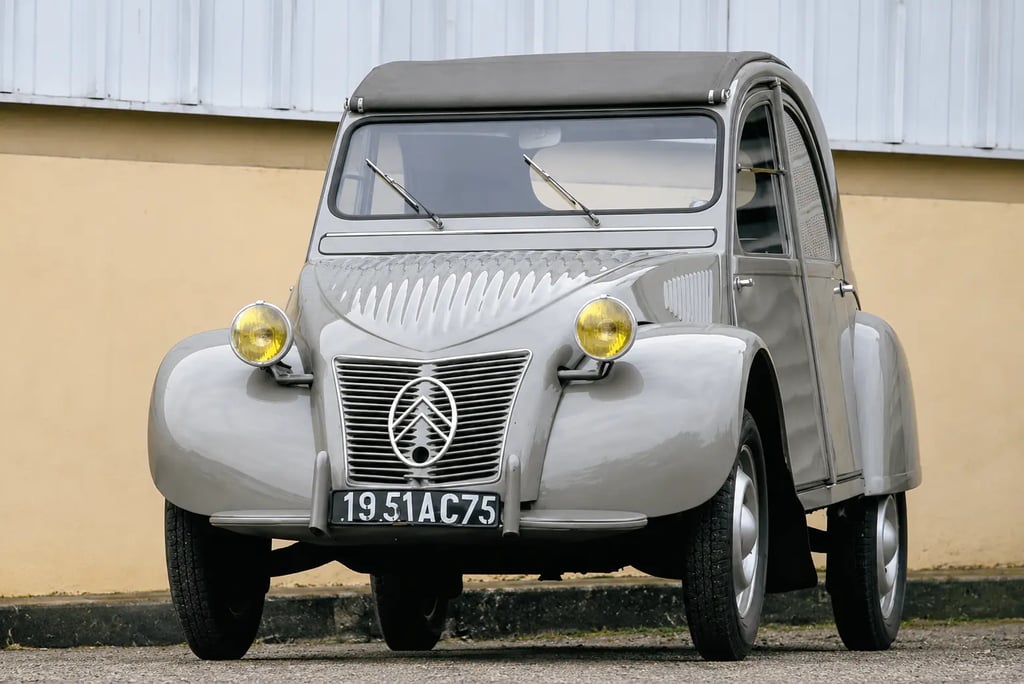 Citroën 2CV clássico cinza visto de frente com design icônico e faróis redondos originais