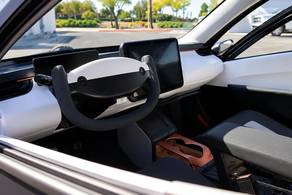 Interior do Aptera Solar EV com volante futurista, telas digitais e cabine minimalista