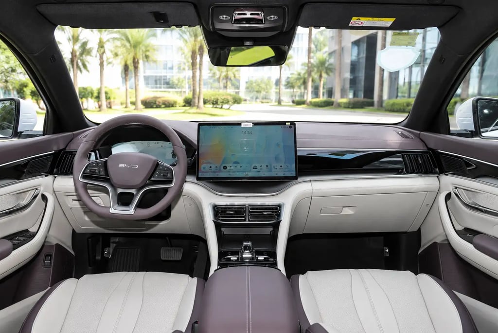 Interior do BYD Song Plus DM-i com painel digital e vista para cenário urbano moderno