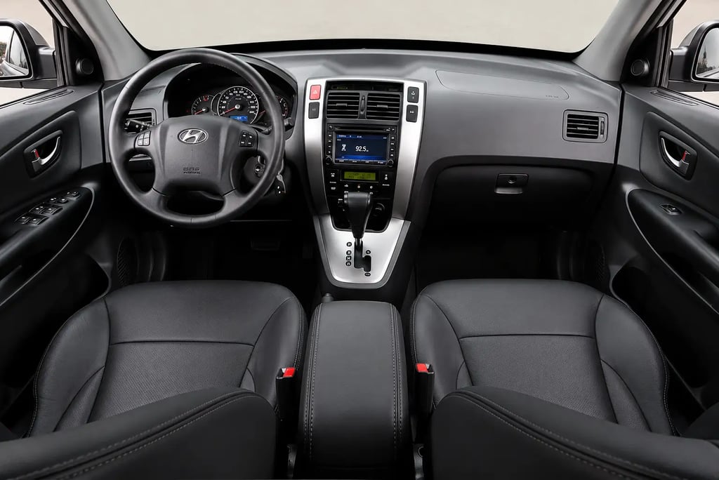 Interior do Hyundai Tucson 2015 com bancos de couro, painel e câmbio automático