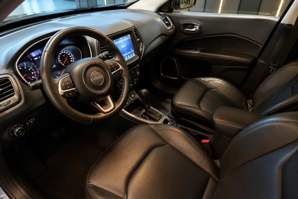Interior do Jeep Compass 2017 com bancos de couro, câmbio automático e central multimídia