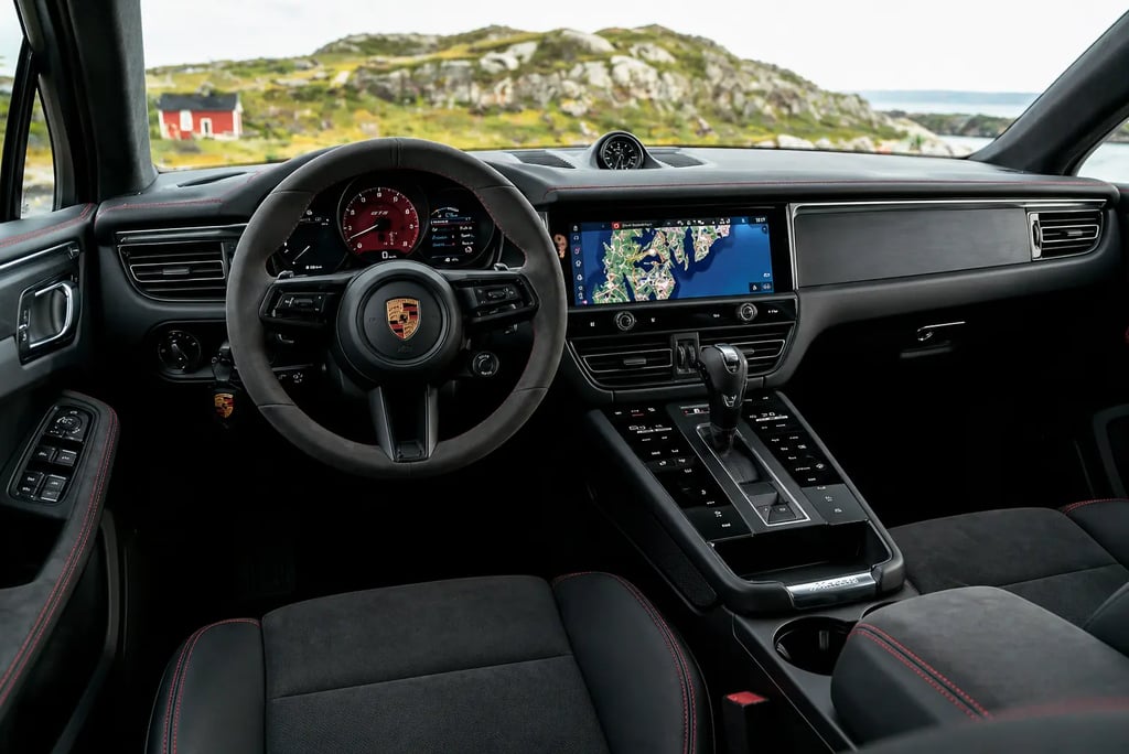 Interior do Porsche Macan com painel digital, multimídia central e acabamento premium esportivo