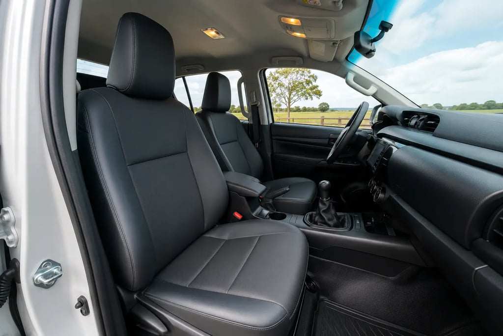 Interior da Toyota Hilux STD 2026 com bancos dianteiros e câmbio manual