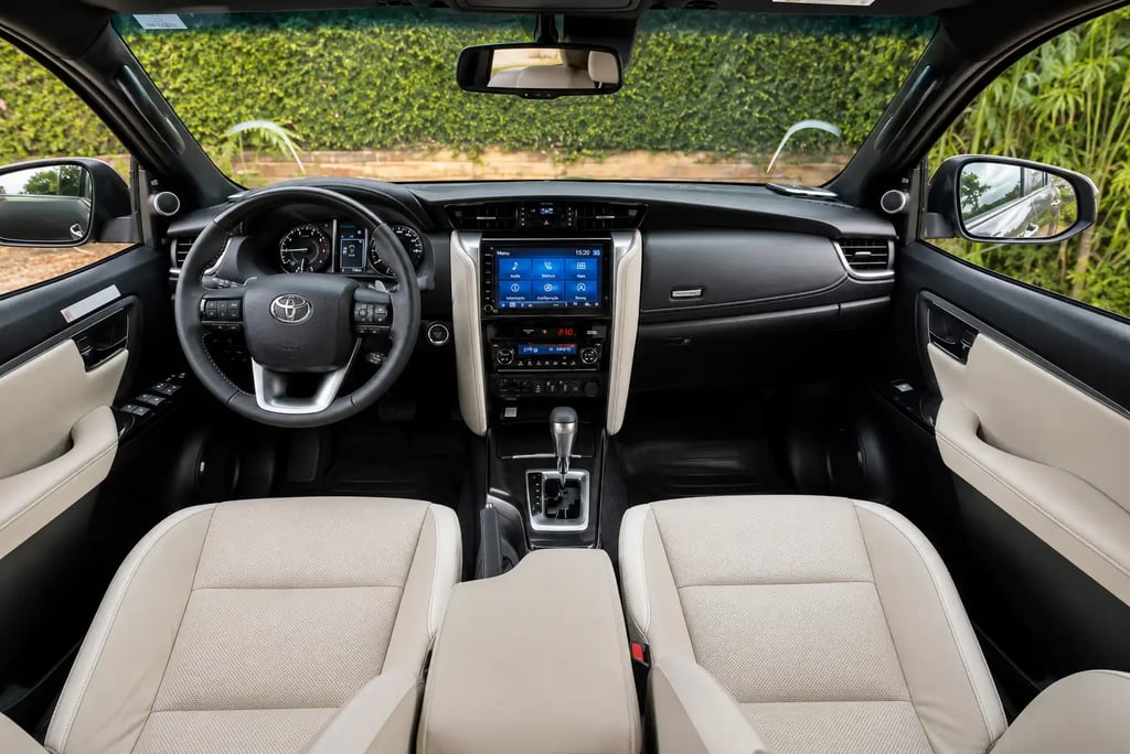 Interior da Toyota SW4 Diamond com painel, central multimídia e bancos em couro bege