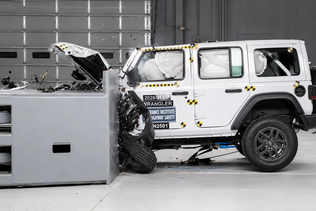 Jeep branco em teste de colisão frontal com airbags acionados em laboratório.