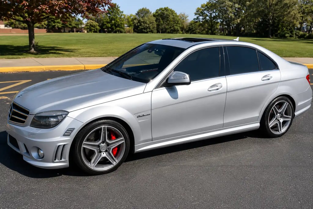 Mercedes C63 AMG prata estacionada com rodas esportivas e visual agressivo