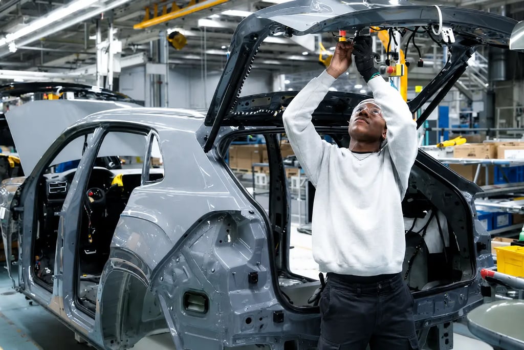Operário realiza montagem de SUV em linha de produção da Volkswagen.