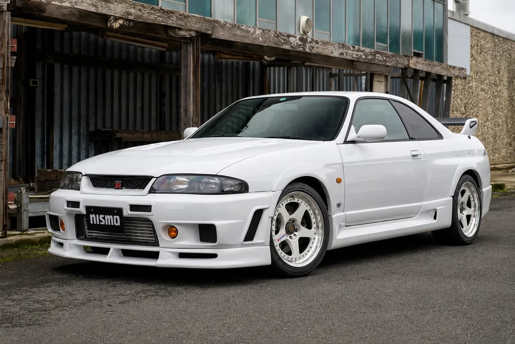 Nissan Skyline GT-R R33 Nismo 400R branco estacionado em cenário industrial