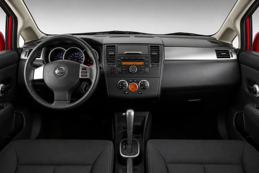 Interior do Nissan Tiida Sedan com painel, volante e câmbio automático em destaque
