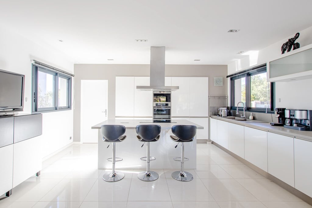 a kitchen with a bar stool and bar stools