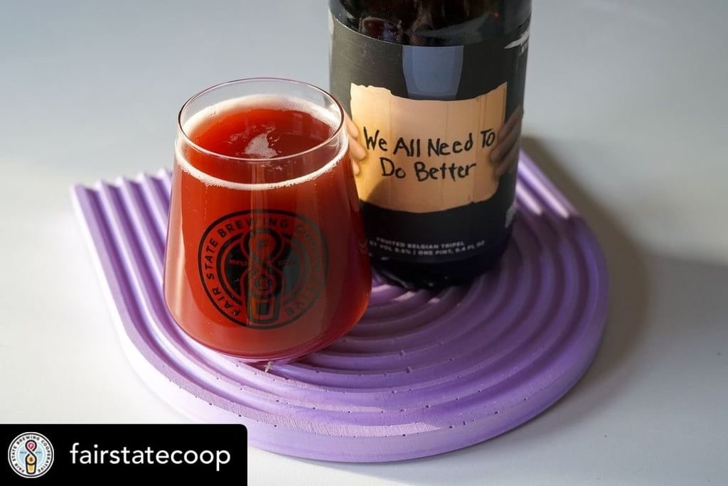 A glass of Fair State and Khonso red fruited Belgian tripel beer next to its bottle.