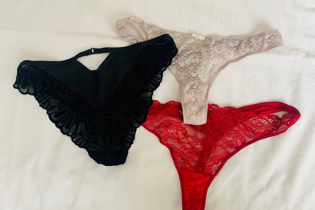 sexy panties laid out on soft bed - black sued panties, a beige flowery thong and a red lace thong