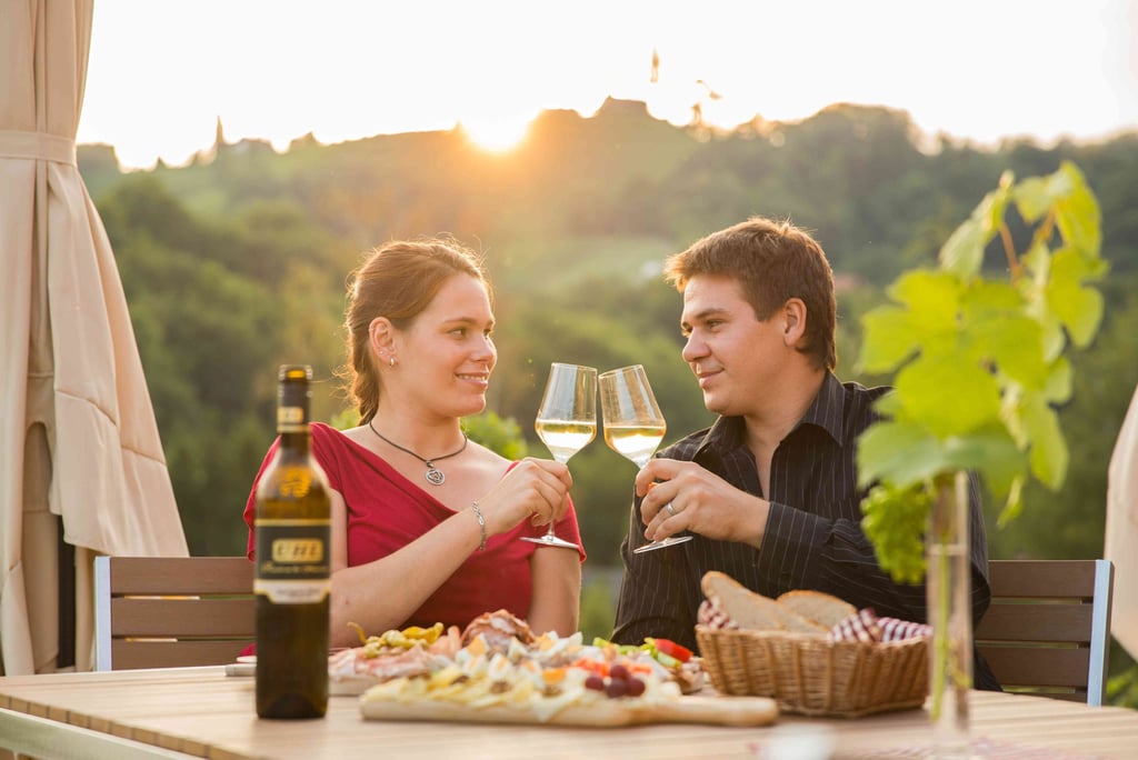 Ein Pärchen das mit zwei Weingläsern anstoßt