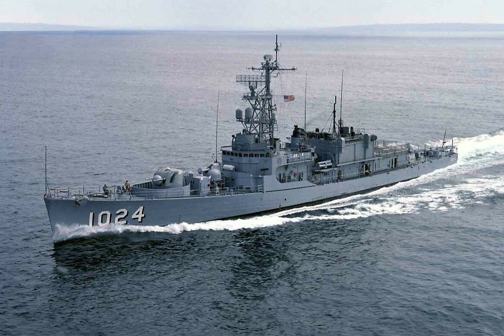 The USS Bridget (DE-1024), a U.S. Navy destroyer escort, underway at sea with white water trailing.