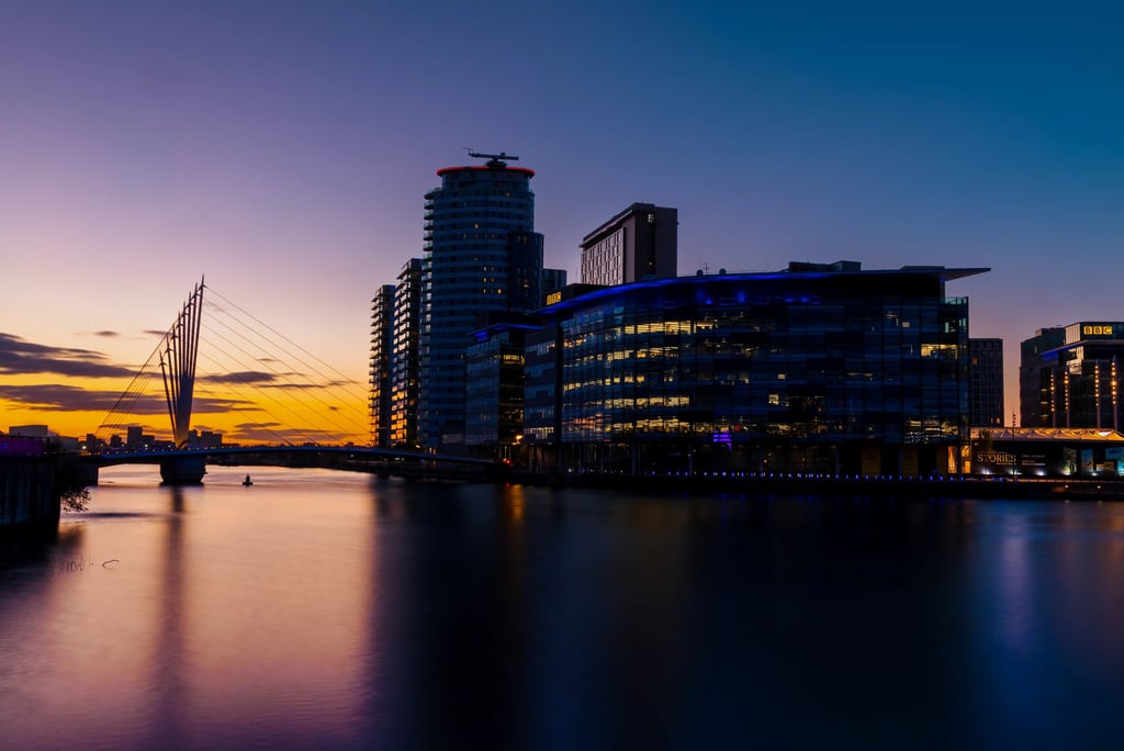 MediaCityUK skyline and Millennium Bridge at sunset over Manchester Ship Canal in Salford Quays.