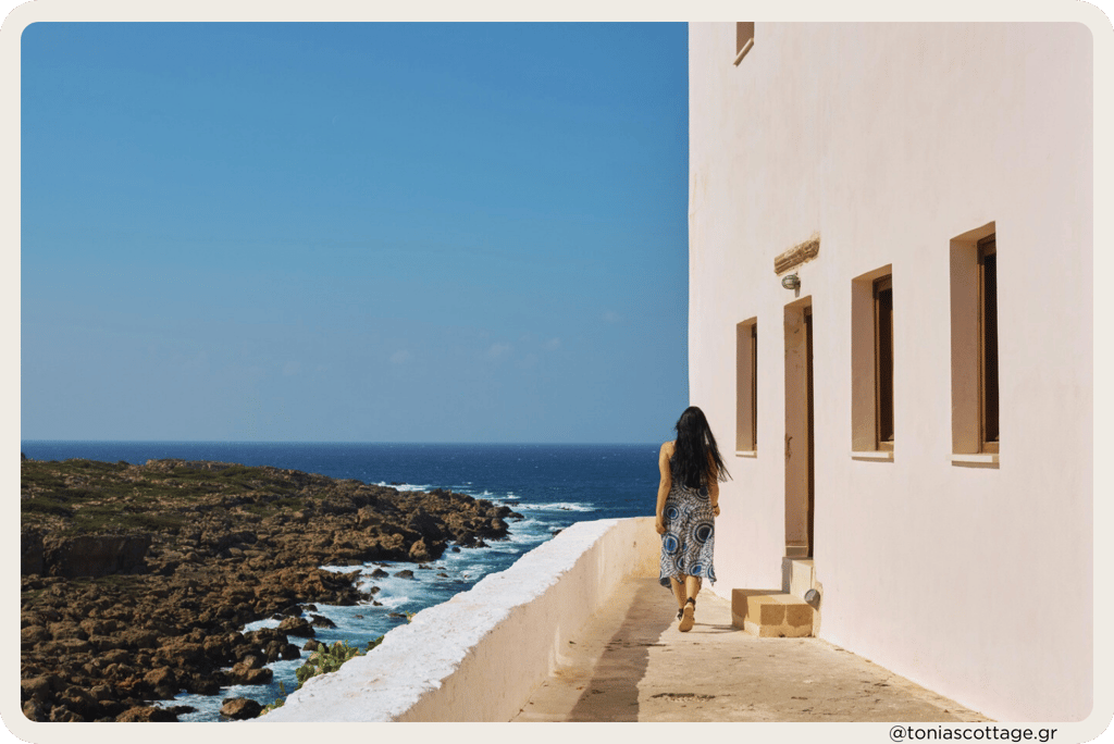 Woman walking by a white church near the sea on the Cretan shore