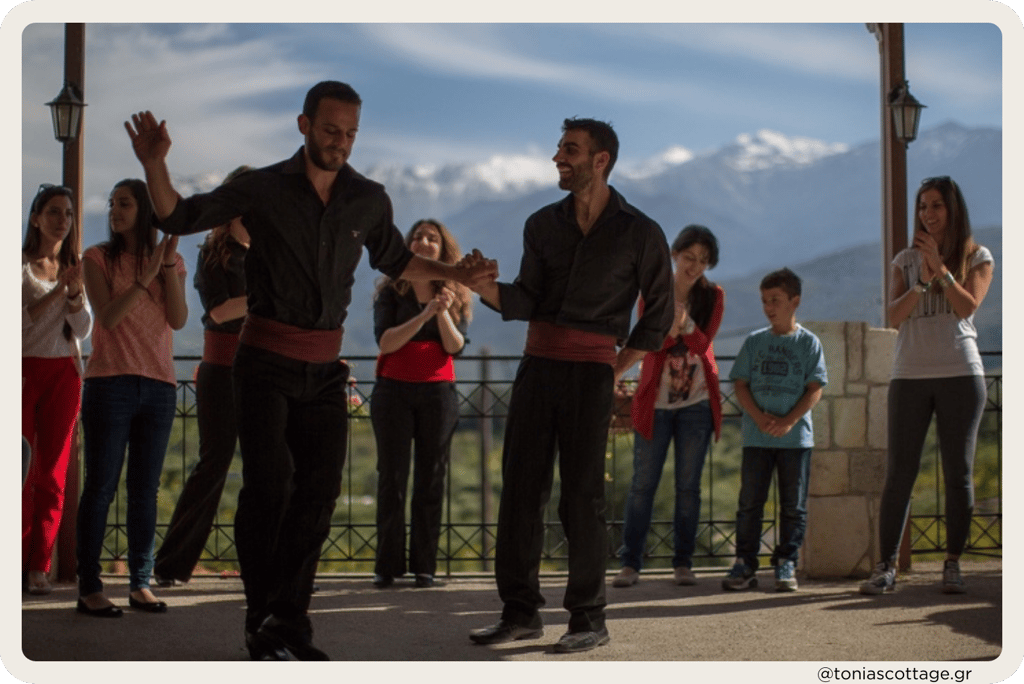 Traditional Cretan dance performance with people watching attentively